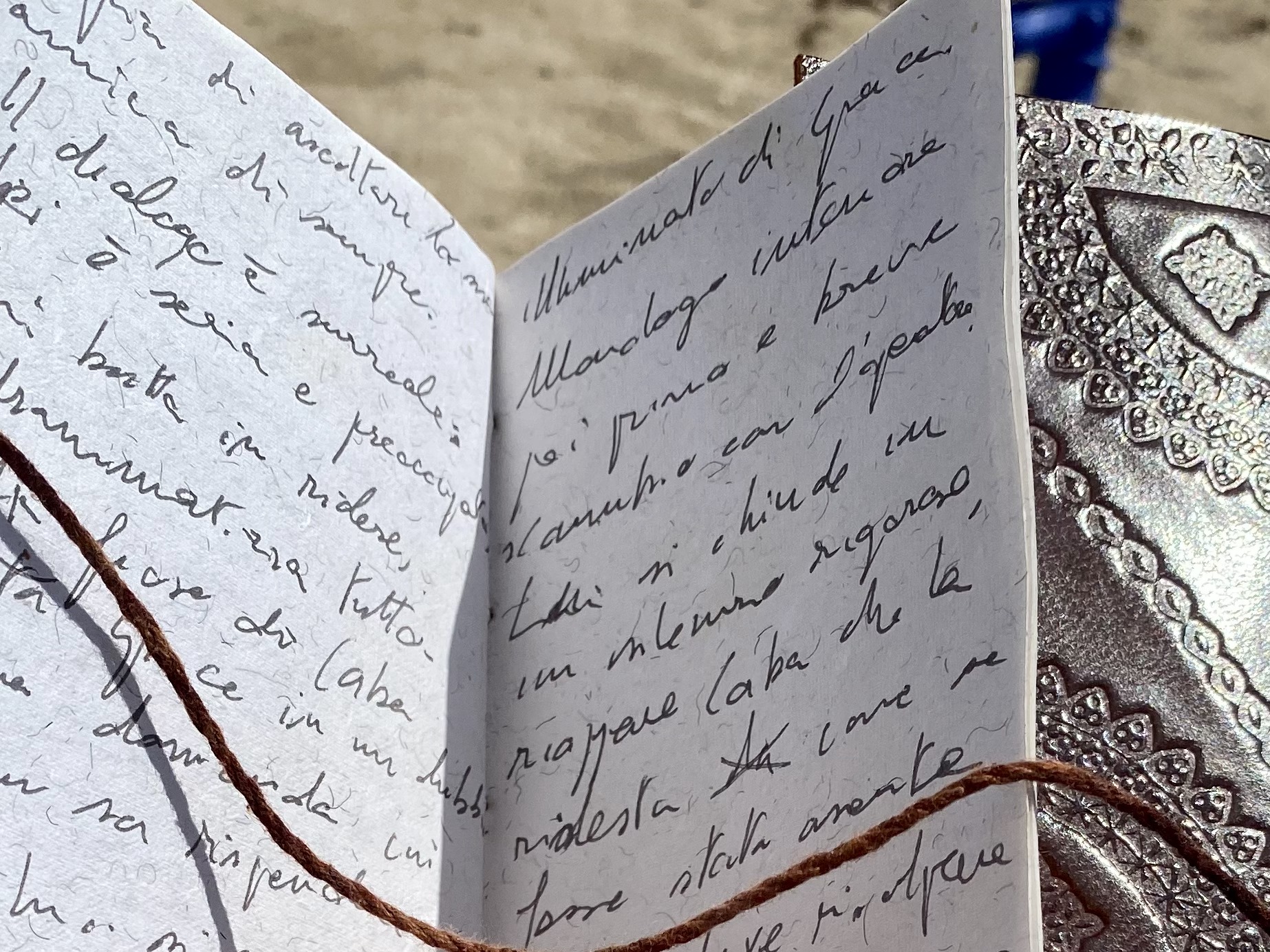 libretto aperto illuminato dal sole con appunti di scrittura a mano su due facciate di Giuliano Pellizzari